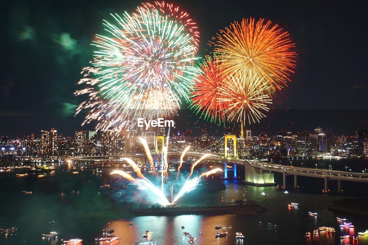 Firework display over river at night