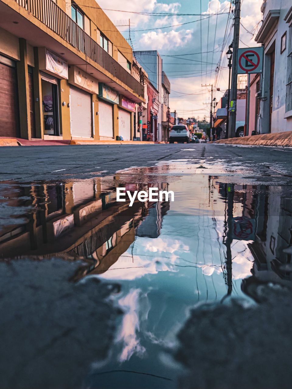 Reflection of building in puddle on street