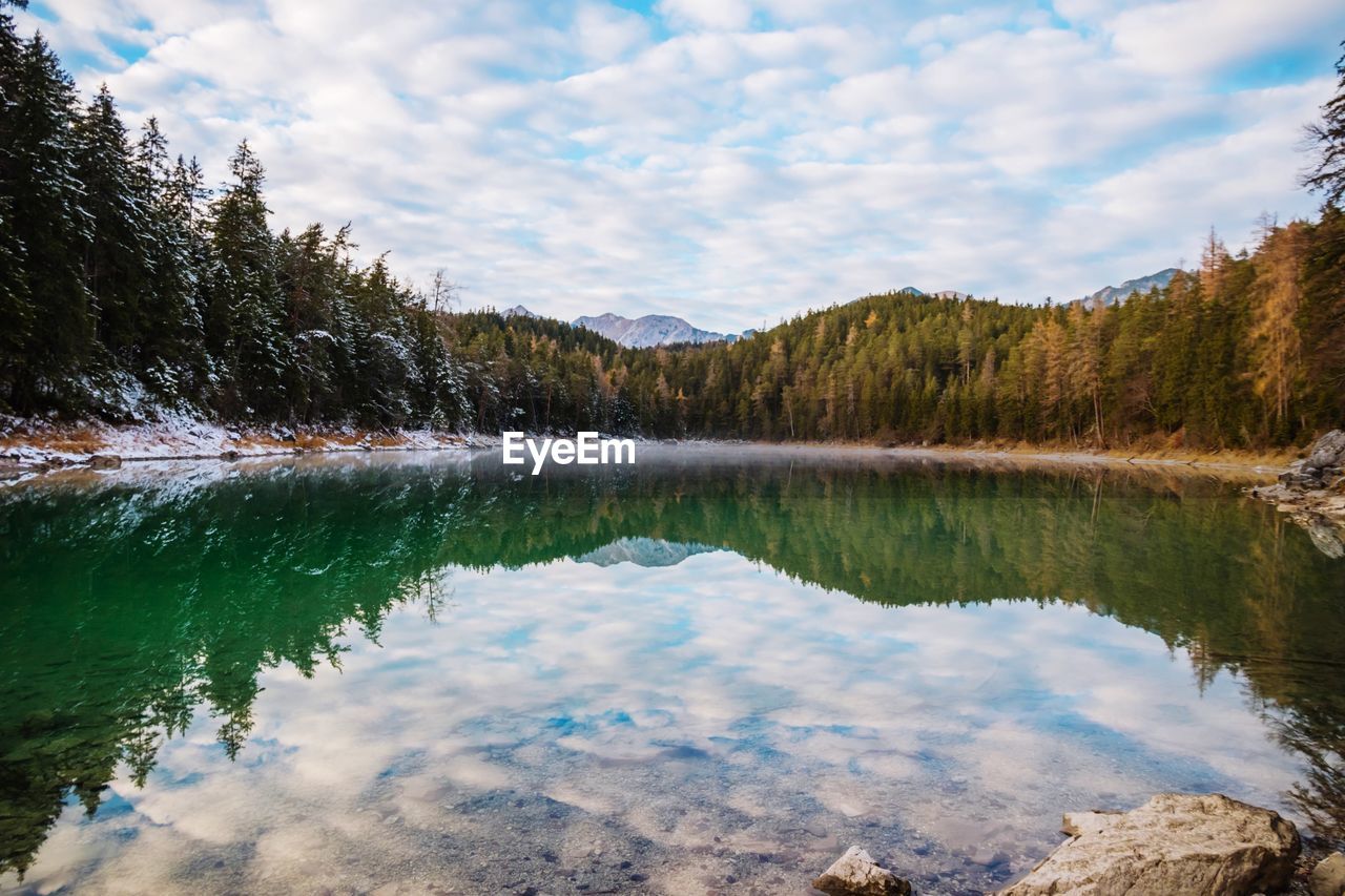 Scenic view of lake by trees against sky