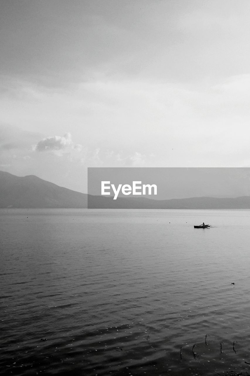 SCENIC VIEW OF SEA BY MOUNTAIN AGAINST SKY