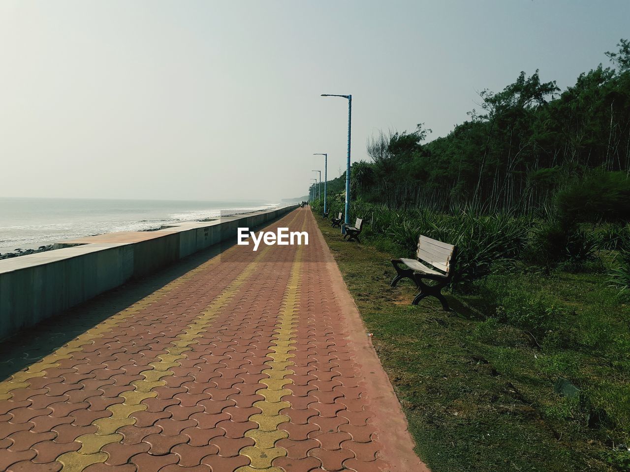 Footpath by street against sky