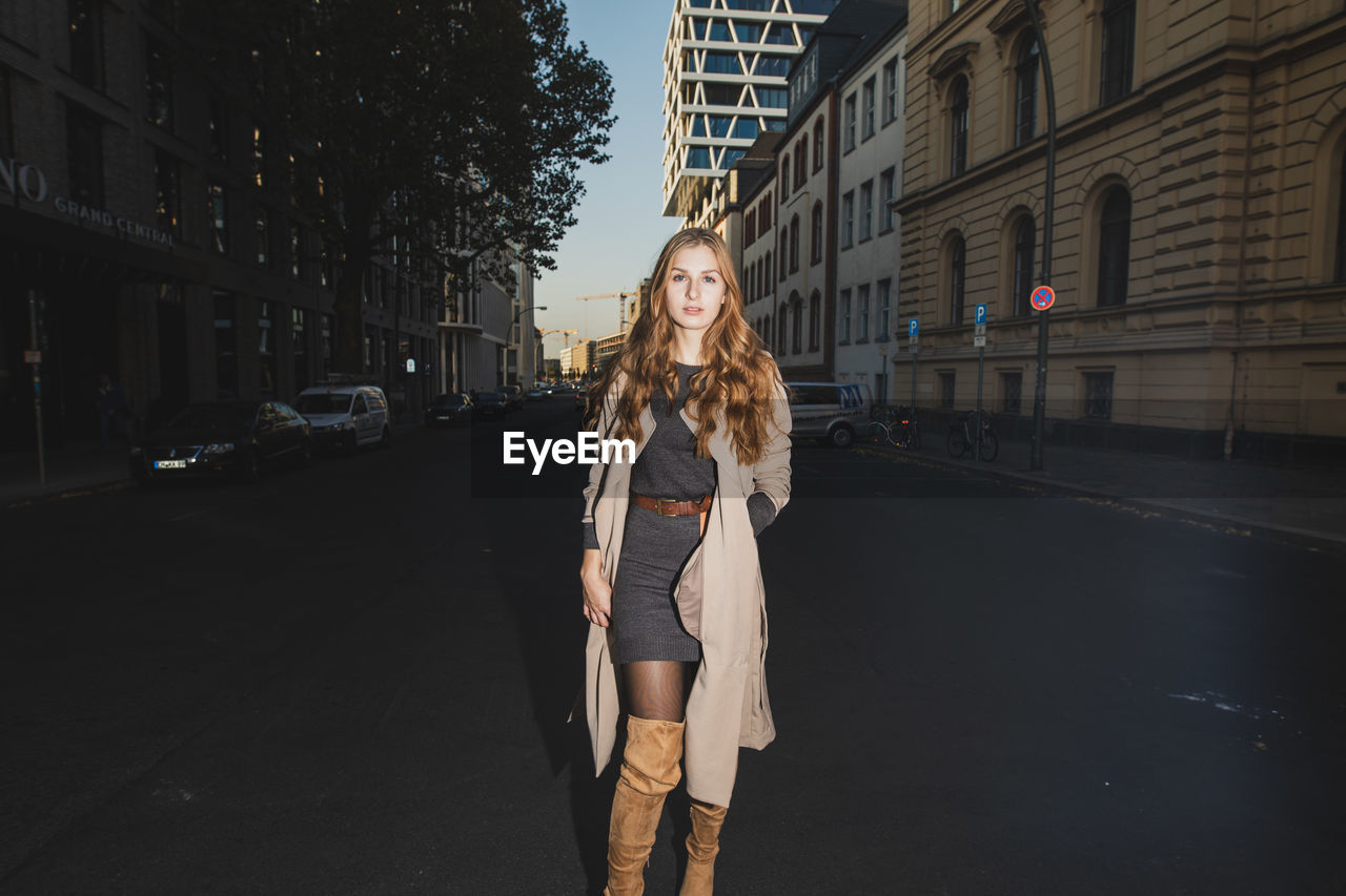 Portrait of young woman on road in city