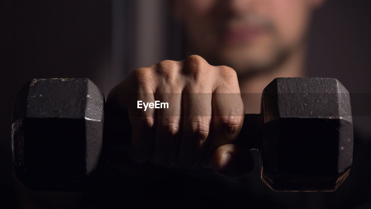 Close-up of man lifting dumbbell