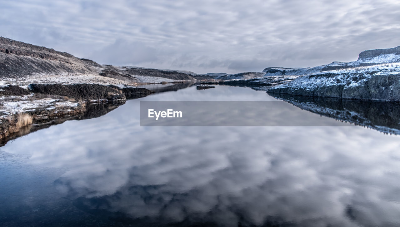 Scenic view of lake against sky during winter