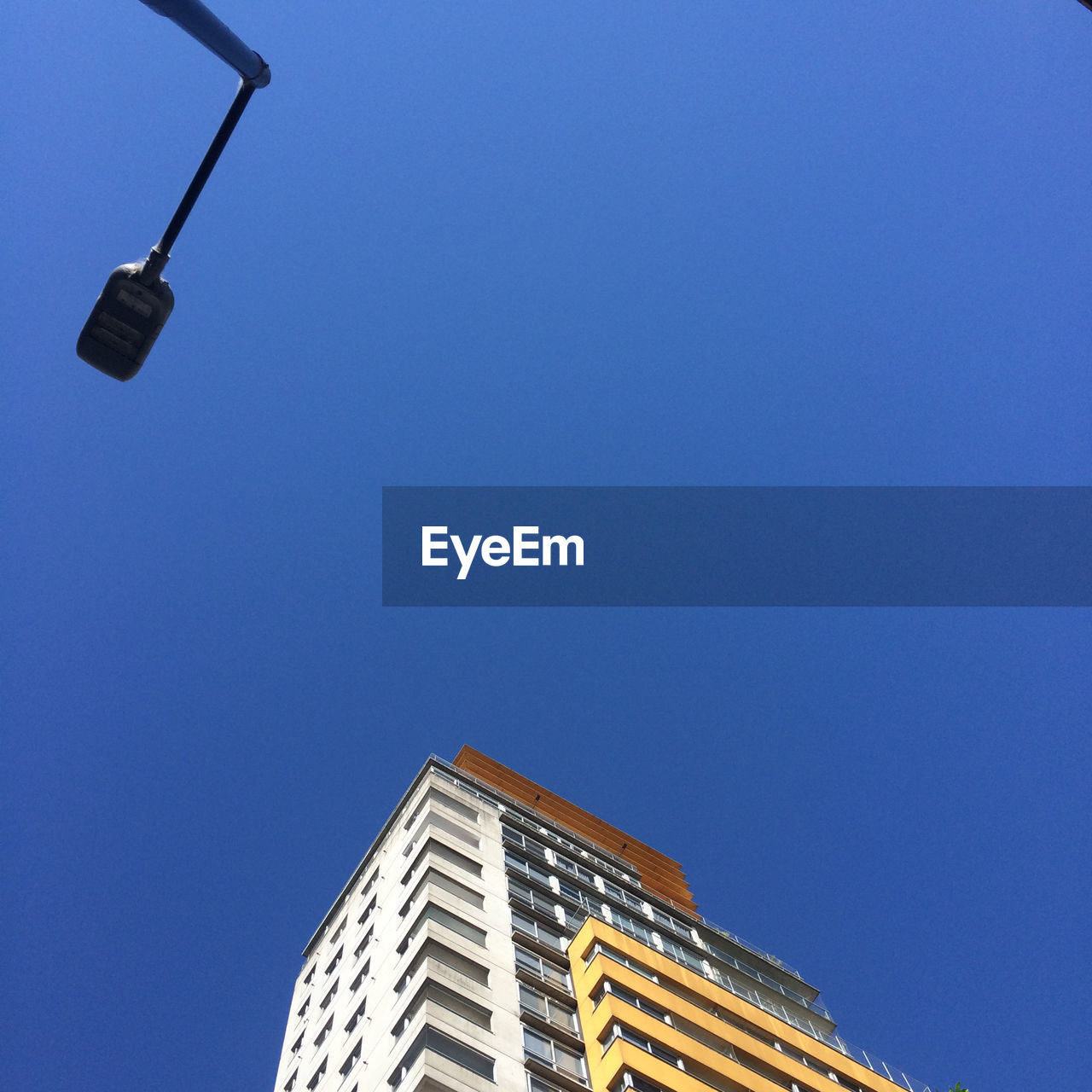 Low angle view of illuminated street light against building