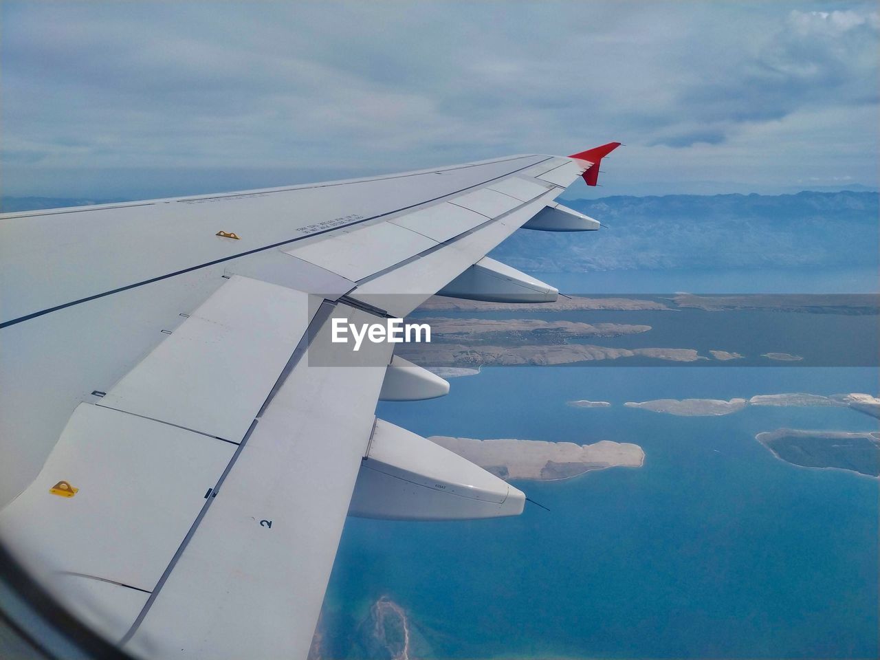 AIRPLANE FLYING IN SKY OVER CLOUDS