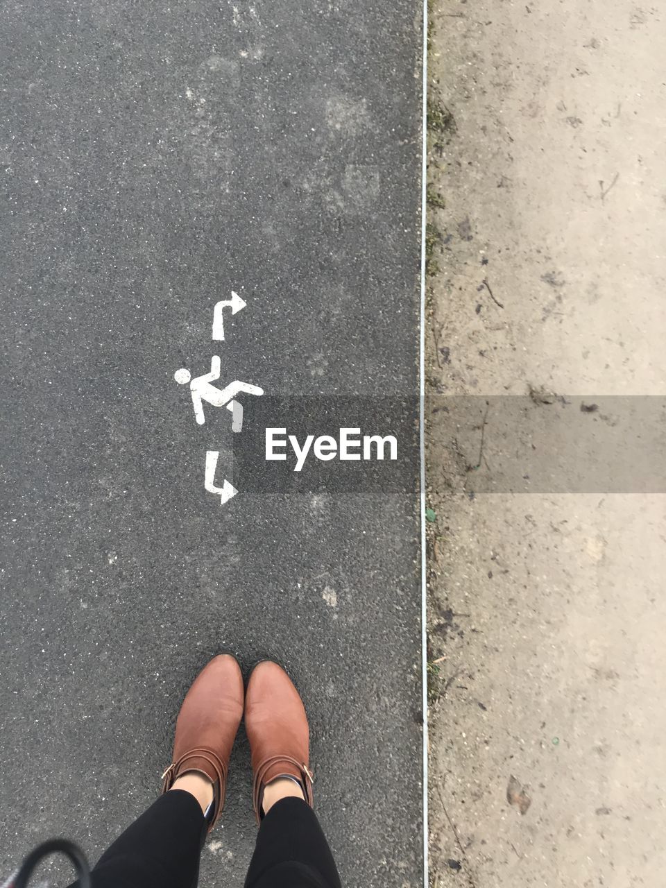 Low section of man standing on road