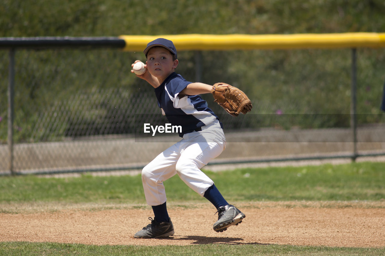 Little league baseball infielder ready to throw to first base