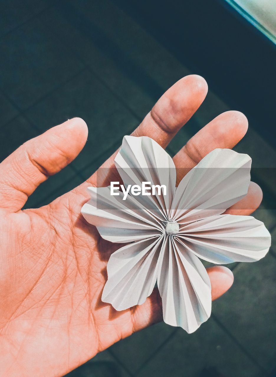 Close-up of hand holding artificial flower