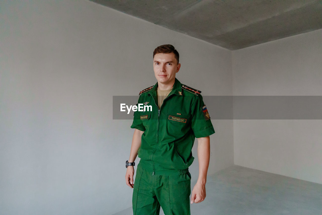 Portrait of soldier standing against wall