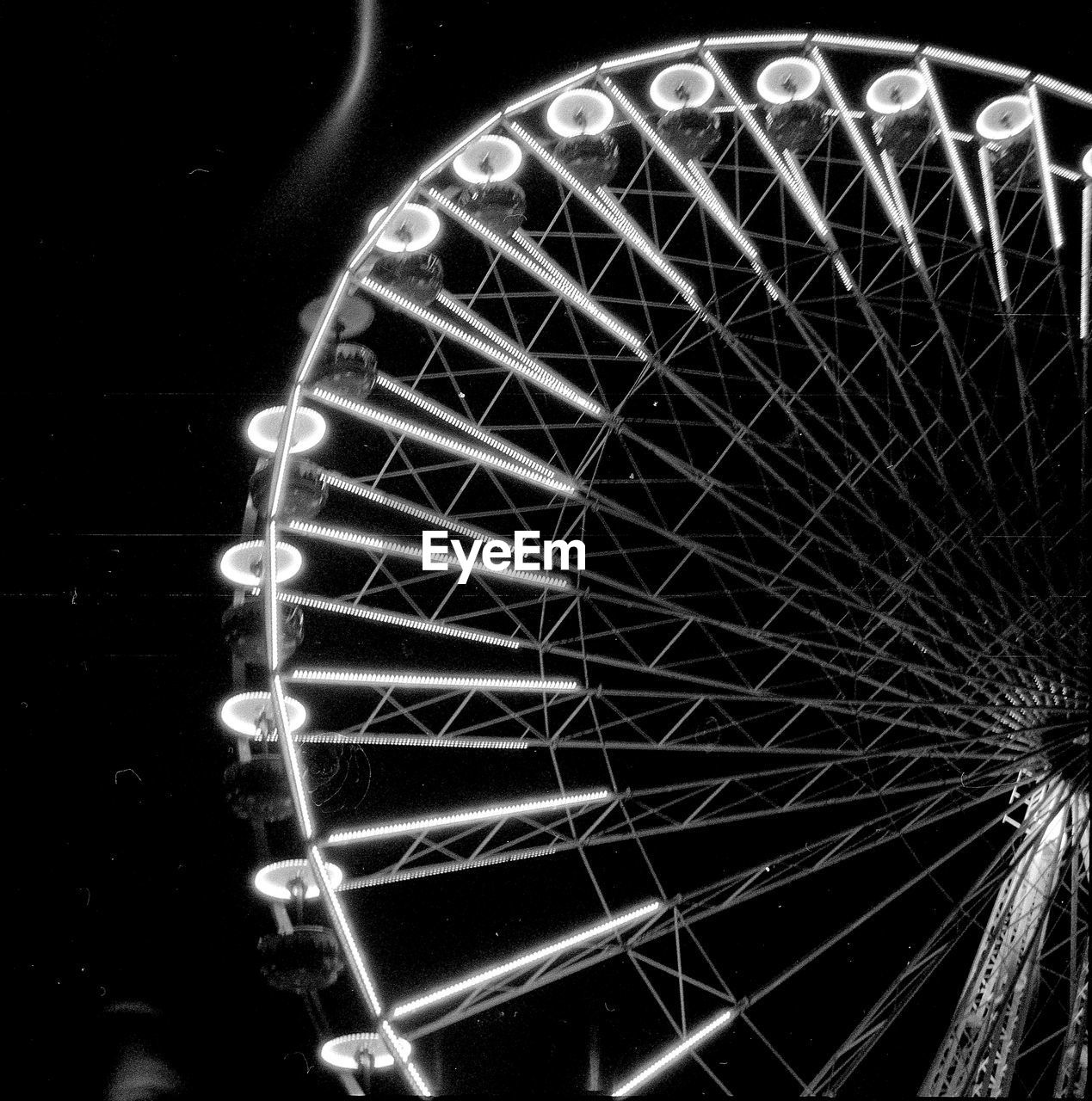 LOW ANGLE VIEW OF ILLUMINATED FERRIS WHEEL AT NIGHT