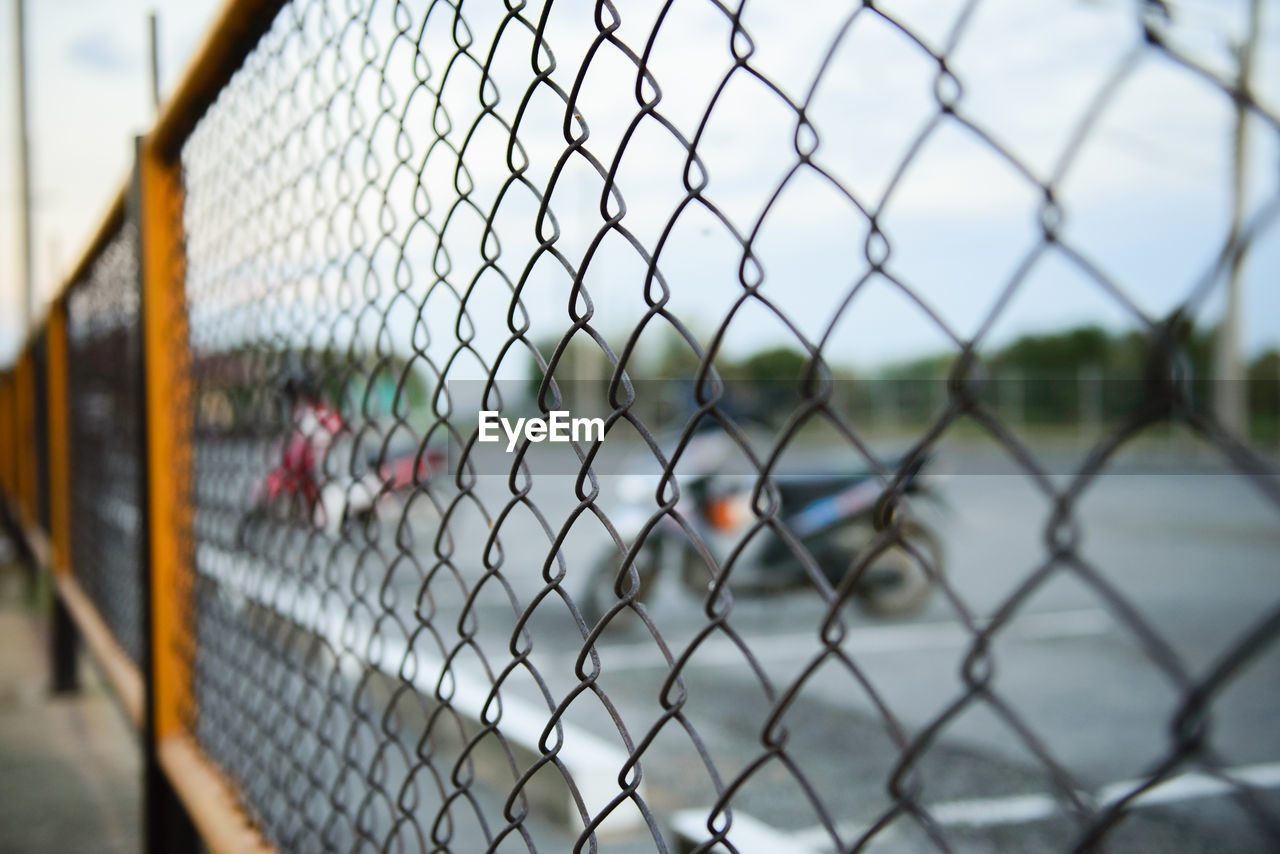 Close-up of chainlink fence at parking lot