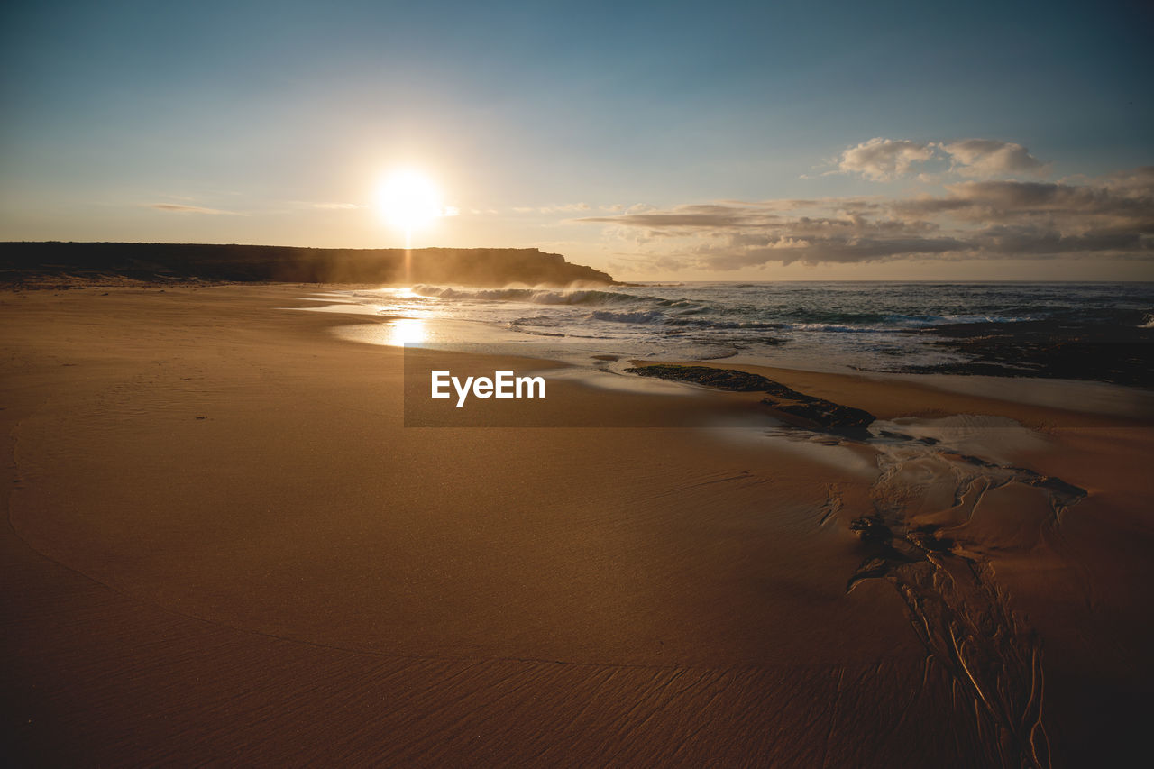 SCENIC VIEW OF BEACH DURING SUNSET