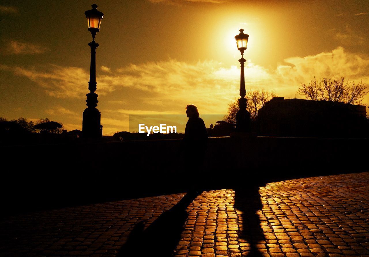 SILHOUETTE MAN ON STREET AT SUNSET