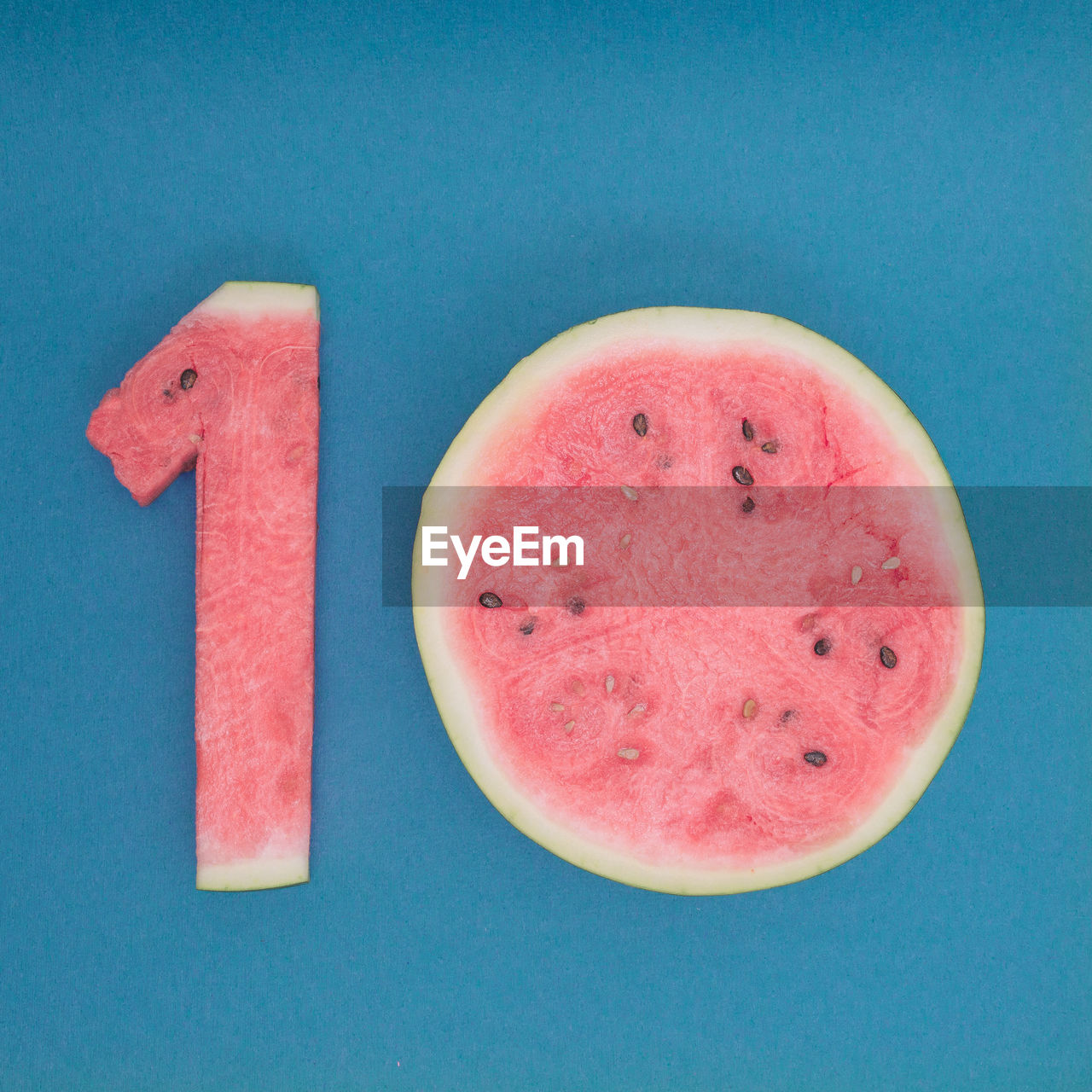 High angle view of watermelon in number 10 on table against blue background