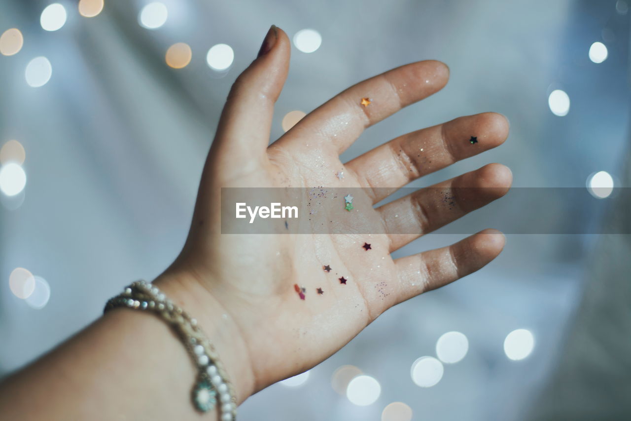 Cropped image of woman with glitter on hand