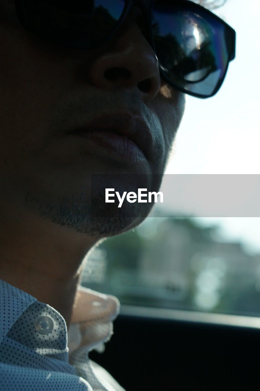 blue, one person, adult, glasses, sunglasses, portrait, headshot, close-up, men, fashion, black, eyewear, vision care, goggles, looking, reflection, transportation, car, mode of transportation, human face, person, motor vehicle, day, outdoors, window, lifestyles, profile view, sky
