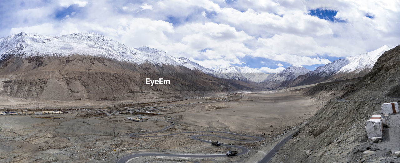 Panorama shot of mountains and blue sky with covered clouds, barren and deserted land in ladakh.