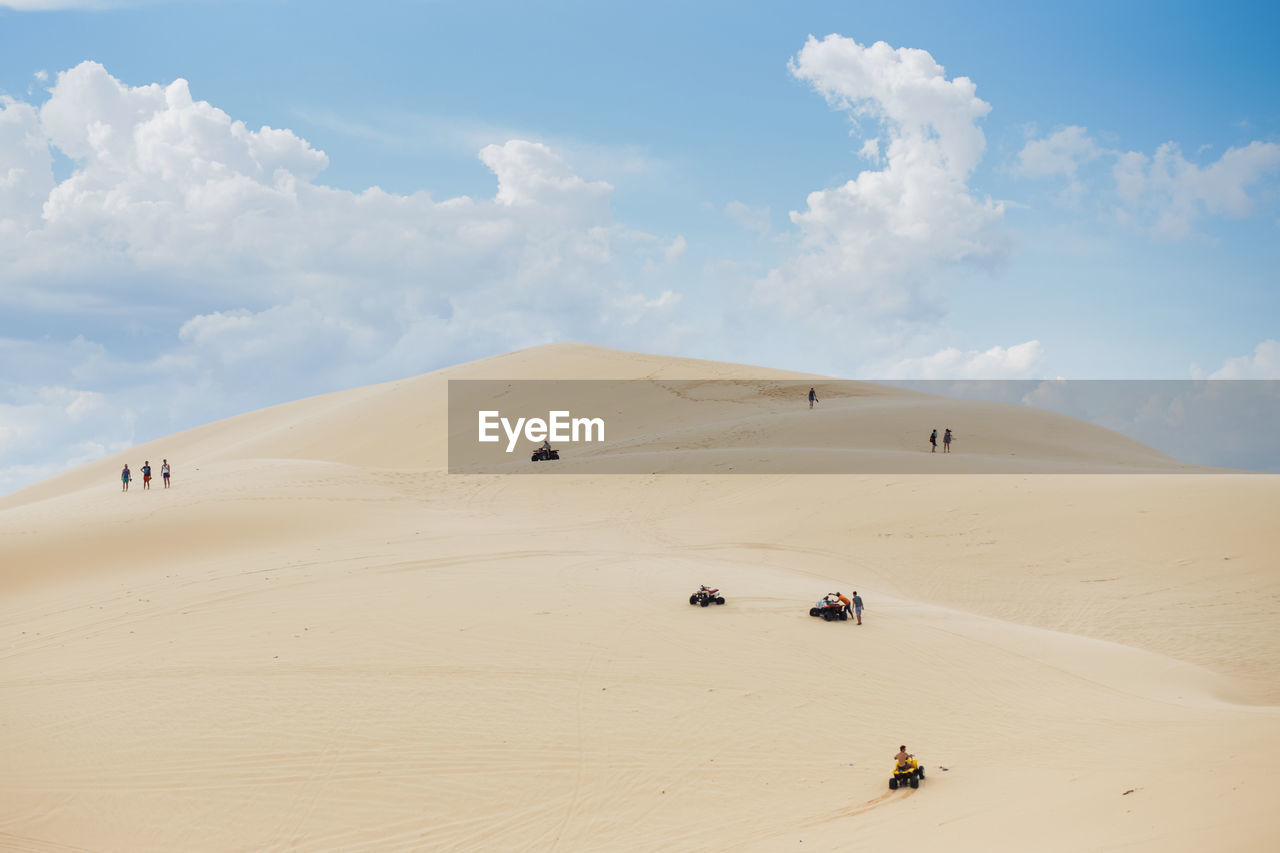 Scenic view of desert against cloudy sky