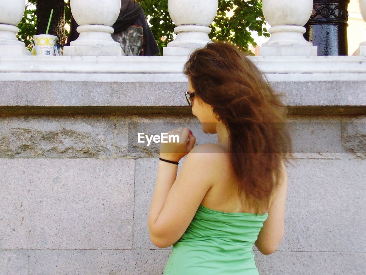 Rear view of woman standing against retaining wall