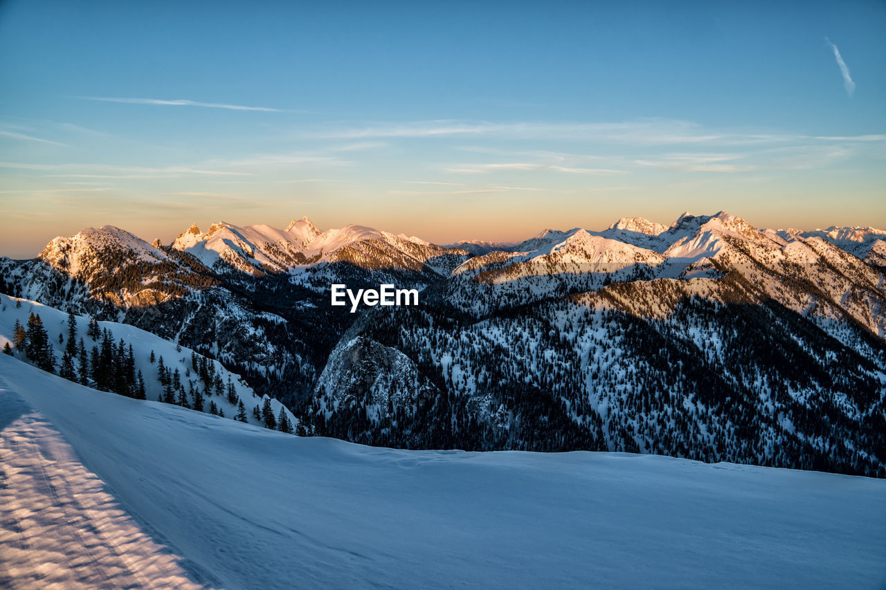 Scenic view of snow covered mountains against sky during sunset