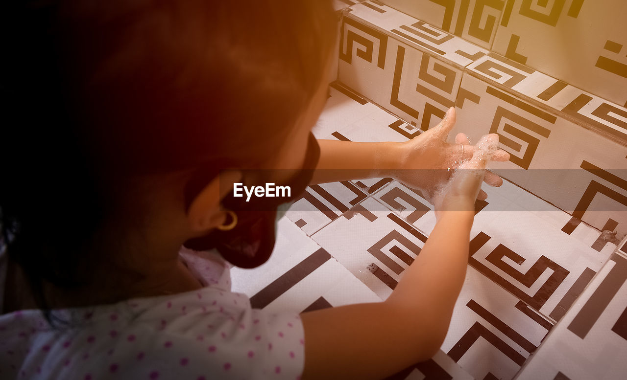 HIGH ANGLE VIEW PORTRAIT OF GIRL WITH TEXT ON MOBILE PHONE