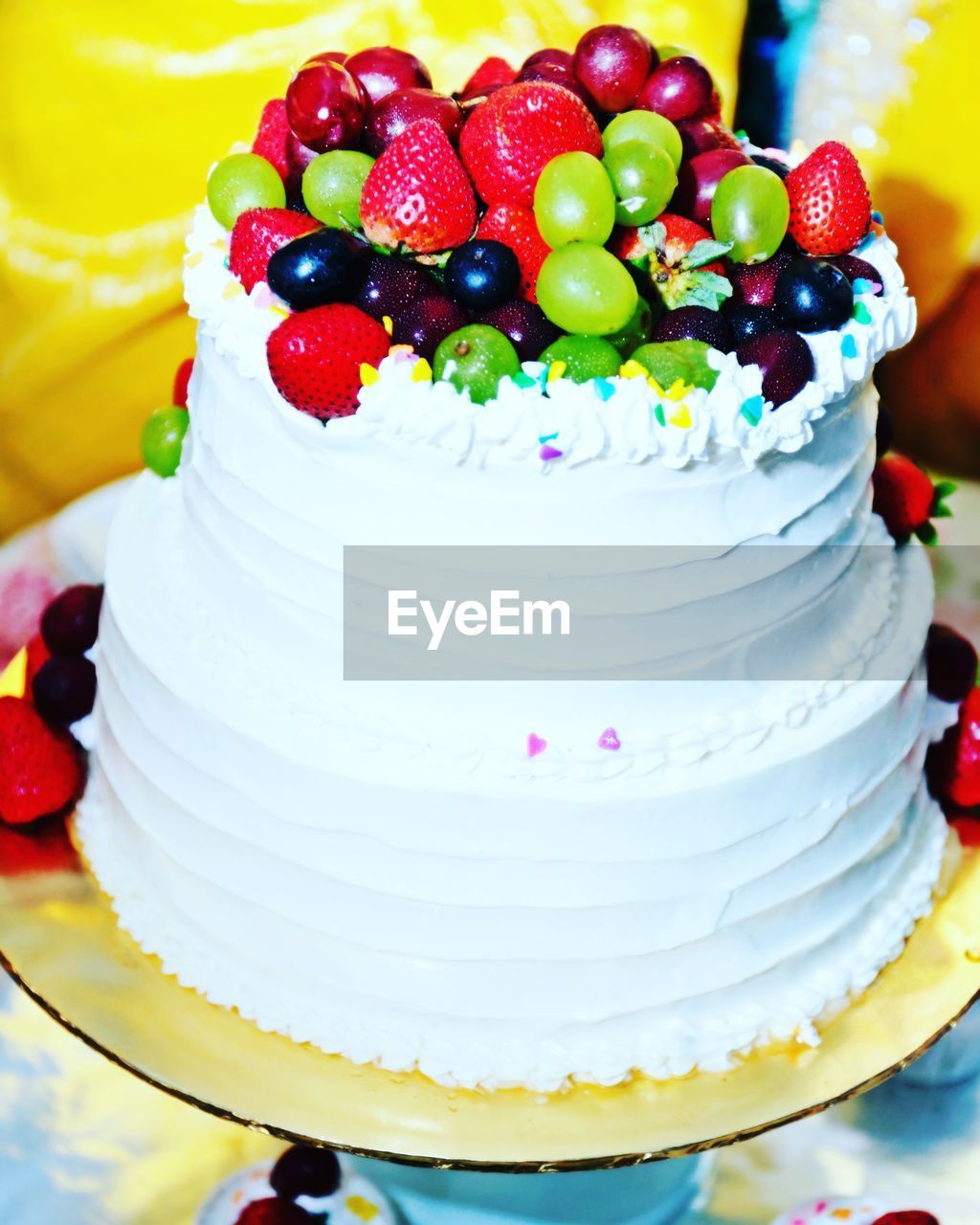 CLOSE-UP OF MULTI COLORED CAKE WITH FRUITS