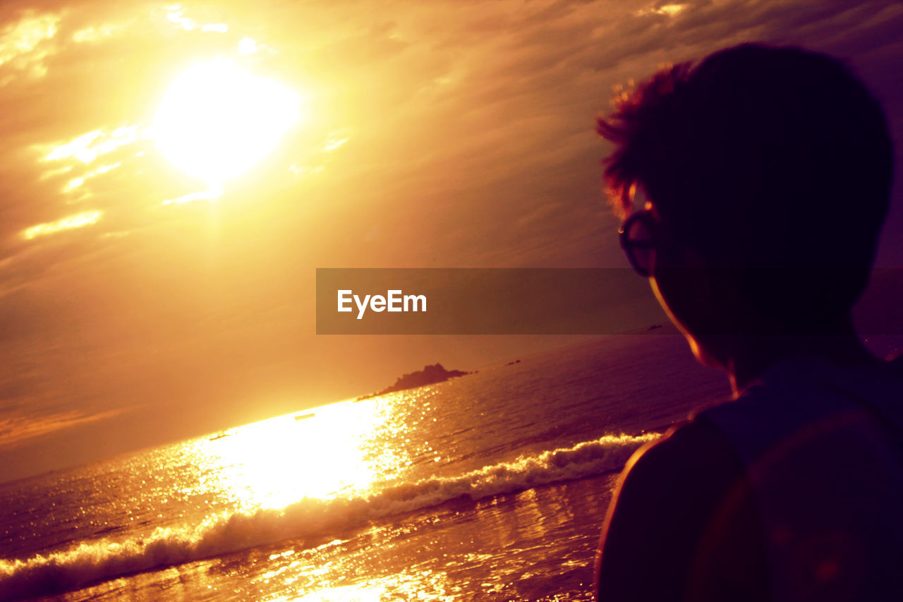 Young man at beach during sunset