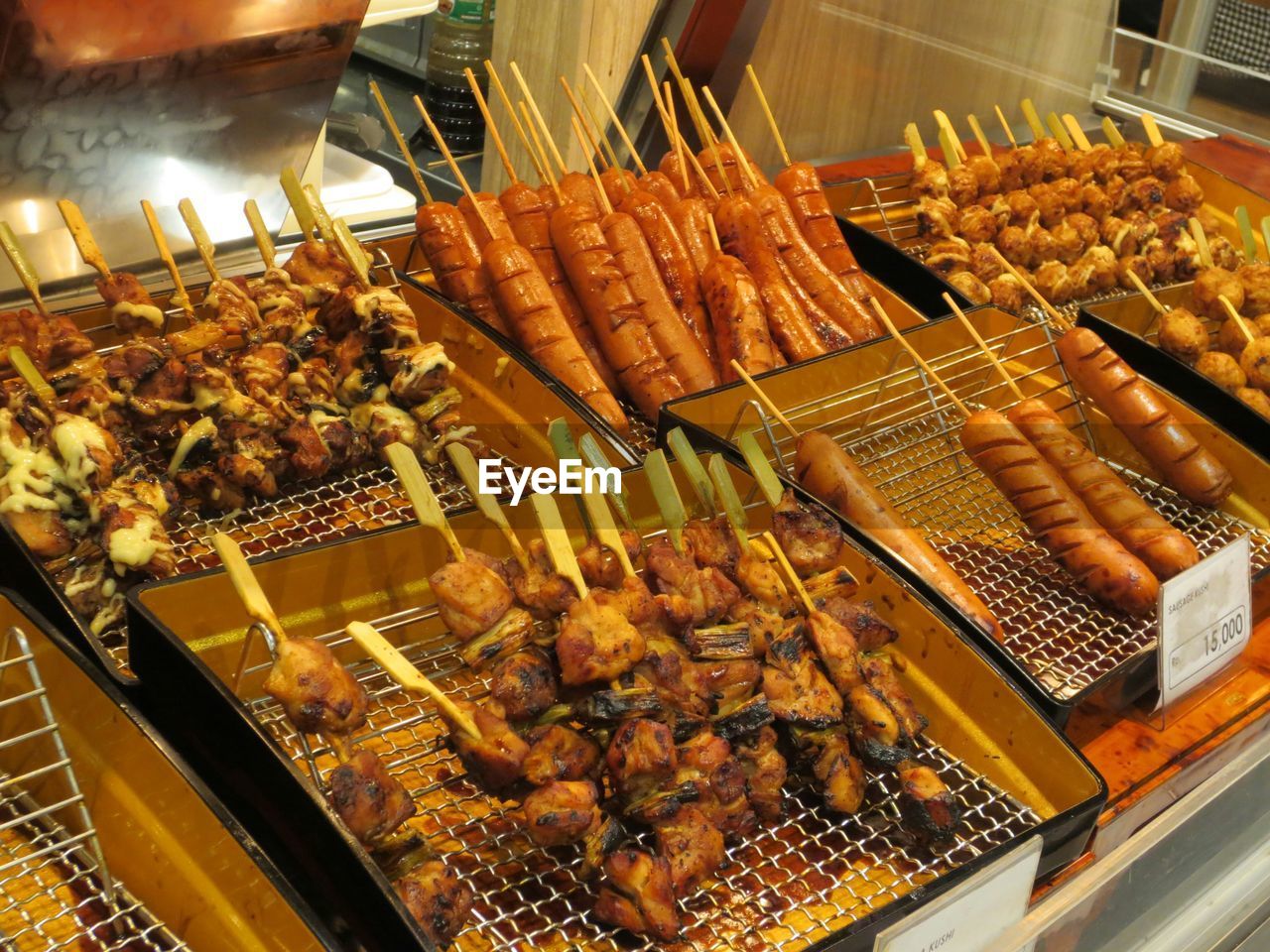 High angle view of fresh meat lollipop in metal containers at store