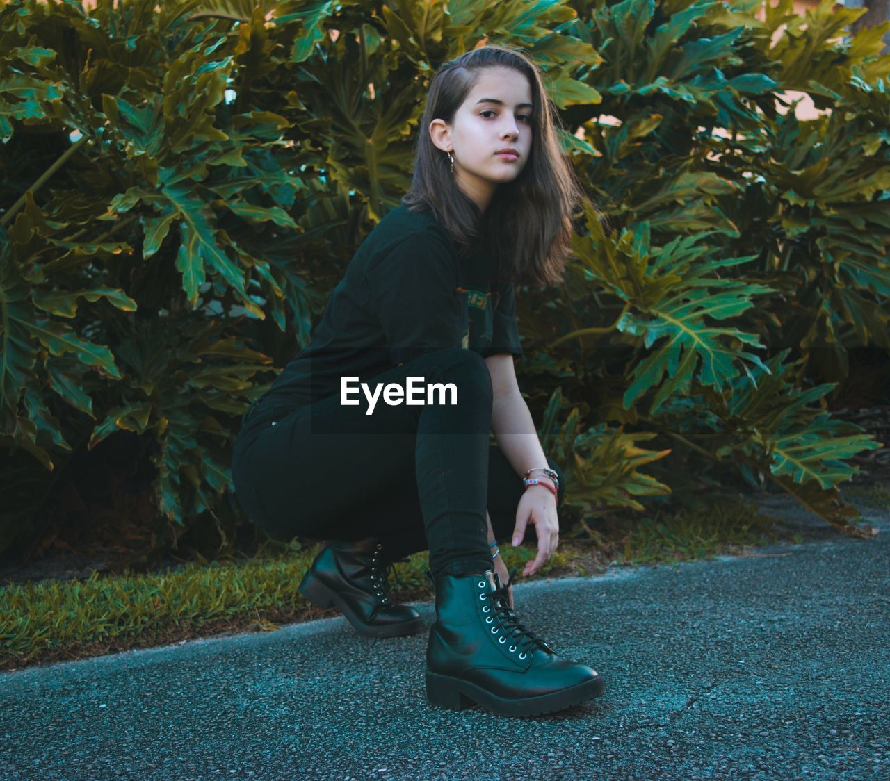 Full length of young woman sitting outdoors