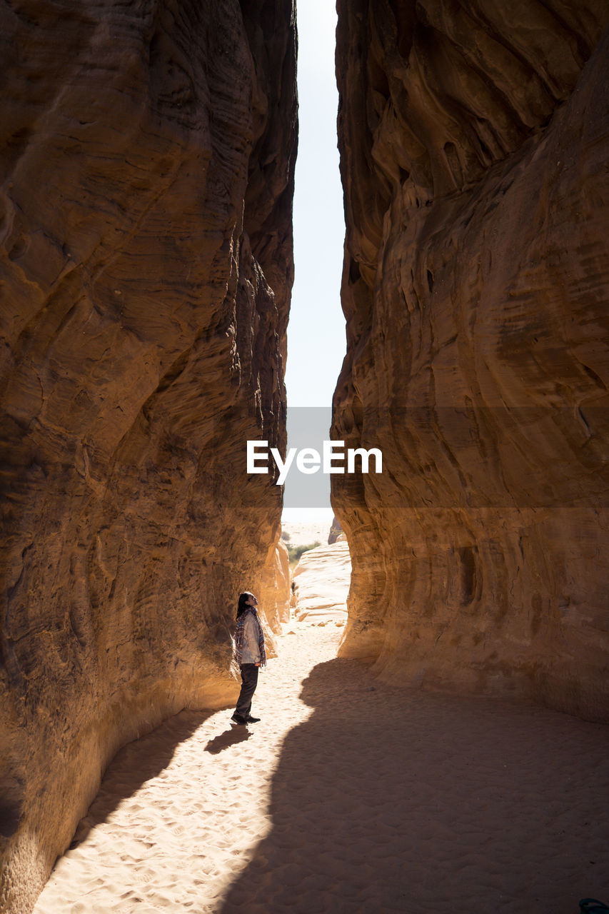 Side view of anonymous traveler enjoying sight the edge of the world during vacation in saudi arabia