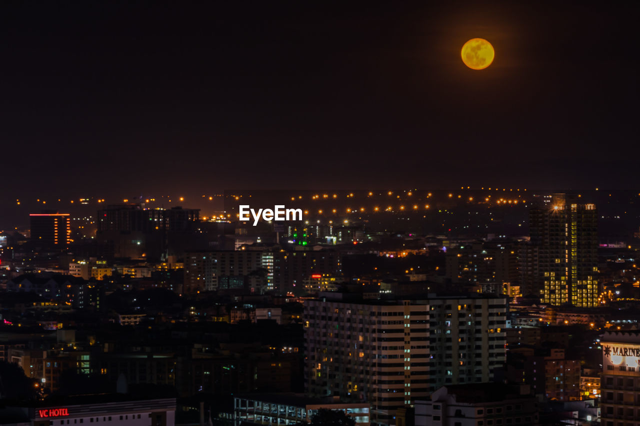 Illuminated buildings in city against sky at night