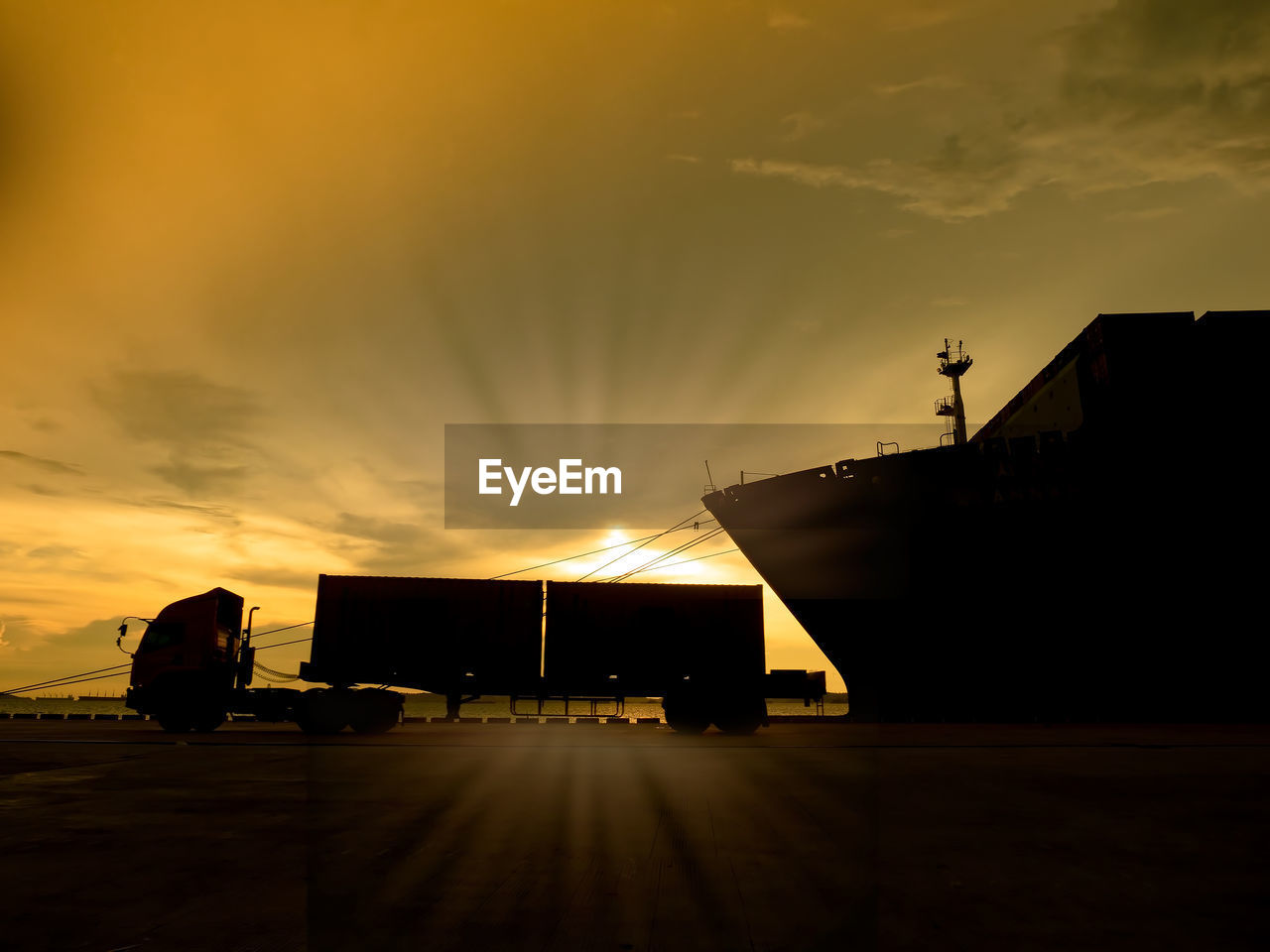 Containers are discharging from vessel by port crane at port of thailand on silhouette, 