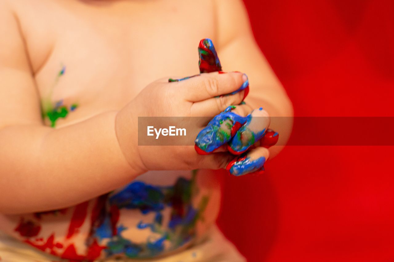 CLOSE-UP OF HAND HOLDING COLORFUL RING