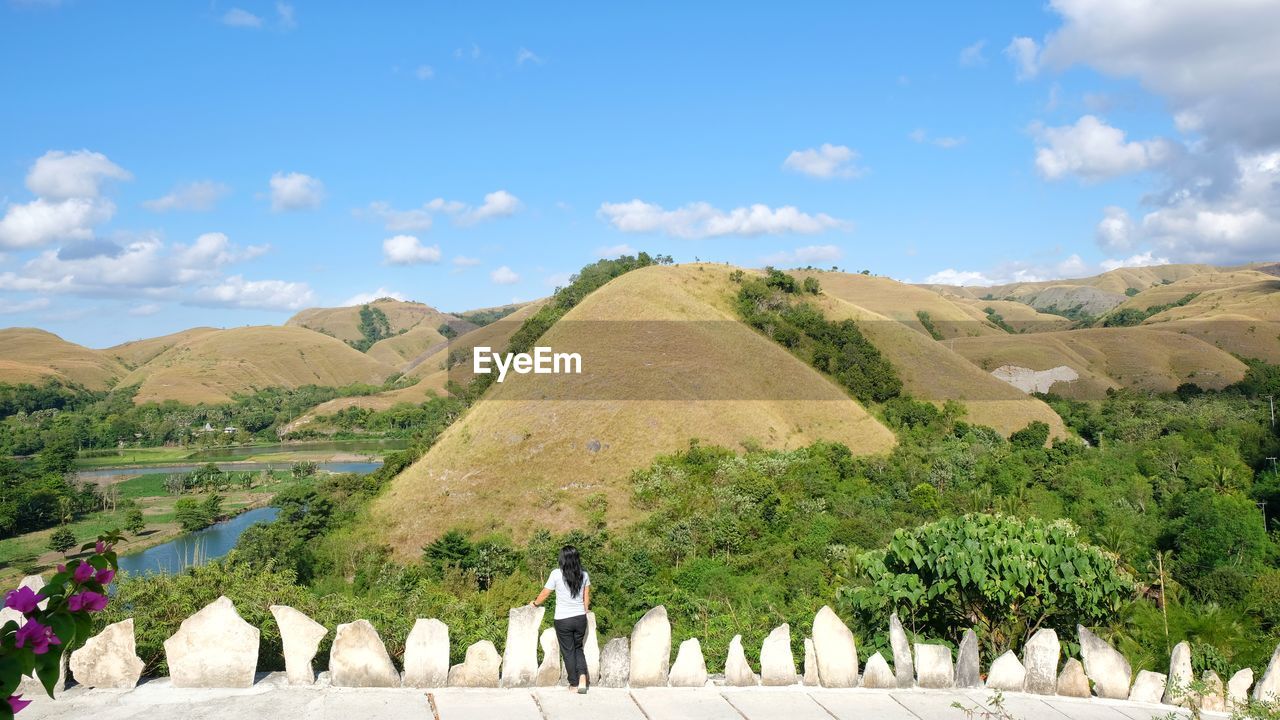 Rear view of woman standing against mountains