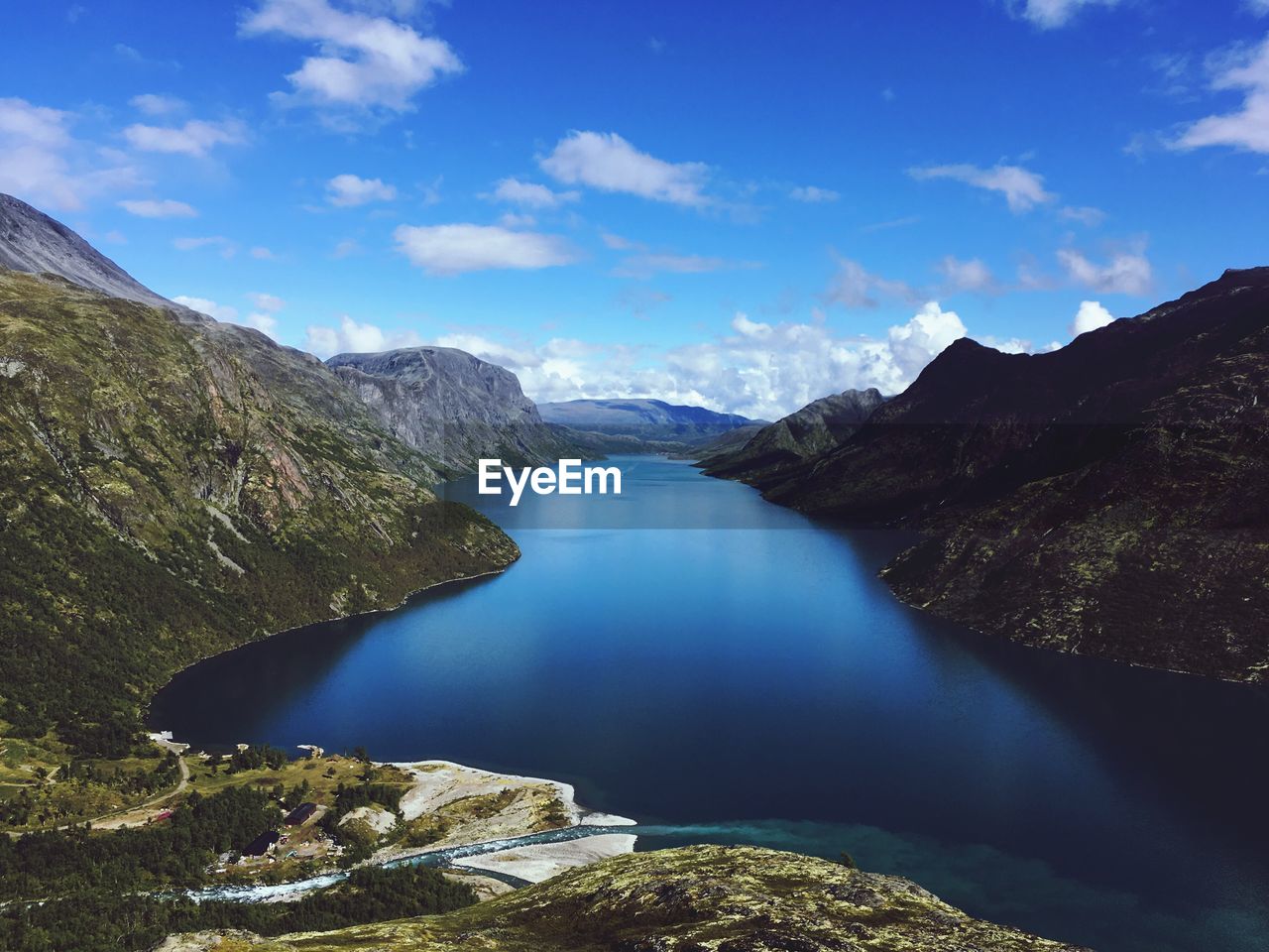 Scenic view of lake and mountains against blue sky