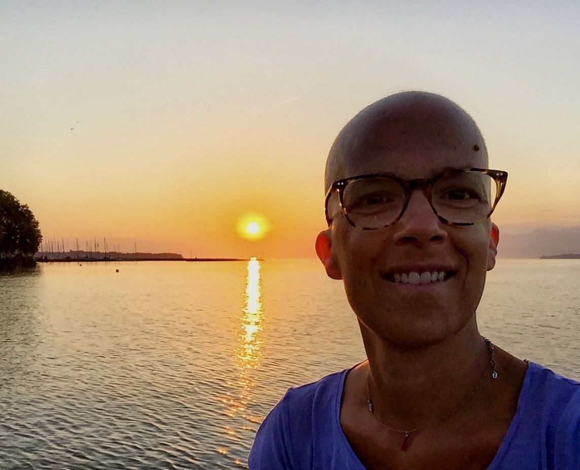 REFLECTION OF WOMAN IN WATER AT SUNSET