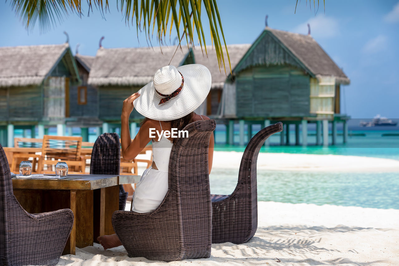 Woman sitting on chair at beach