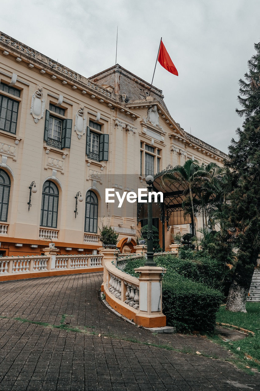architecture, building exterior, built structure, flag, town, city, nature, building, sky, patriotism, urban area, no people, house, plant, history, the past, street, day, travel destinations, cloud, outdoors, tree, neighbourhood, estate, travel, road, tourism