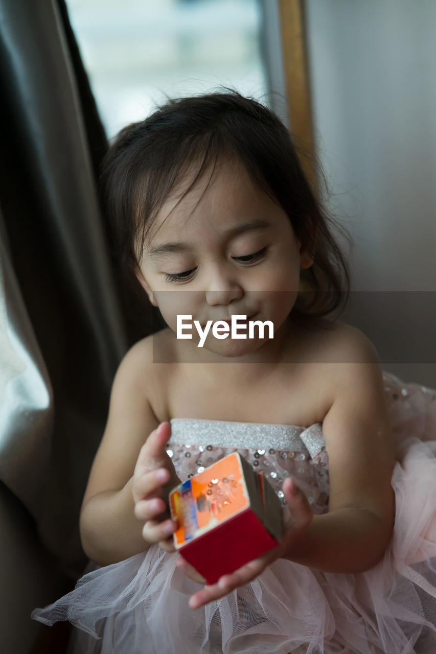 Toddler in ballerina tutu holding a book.