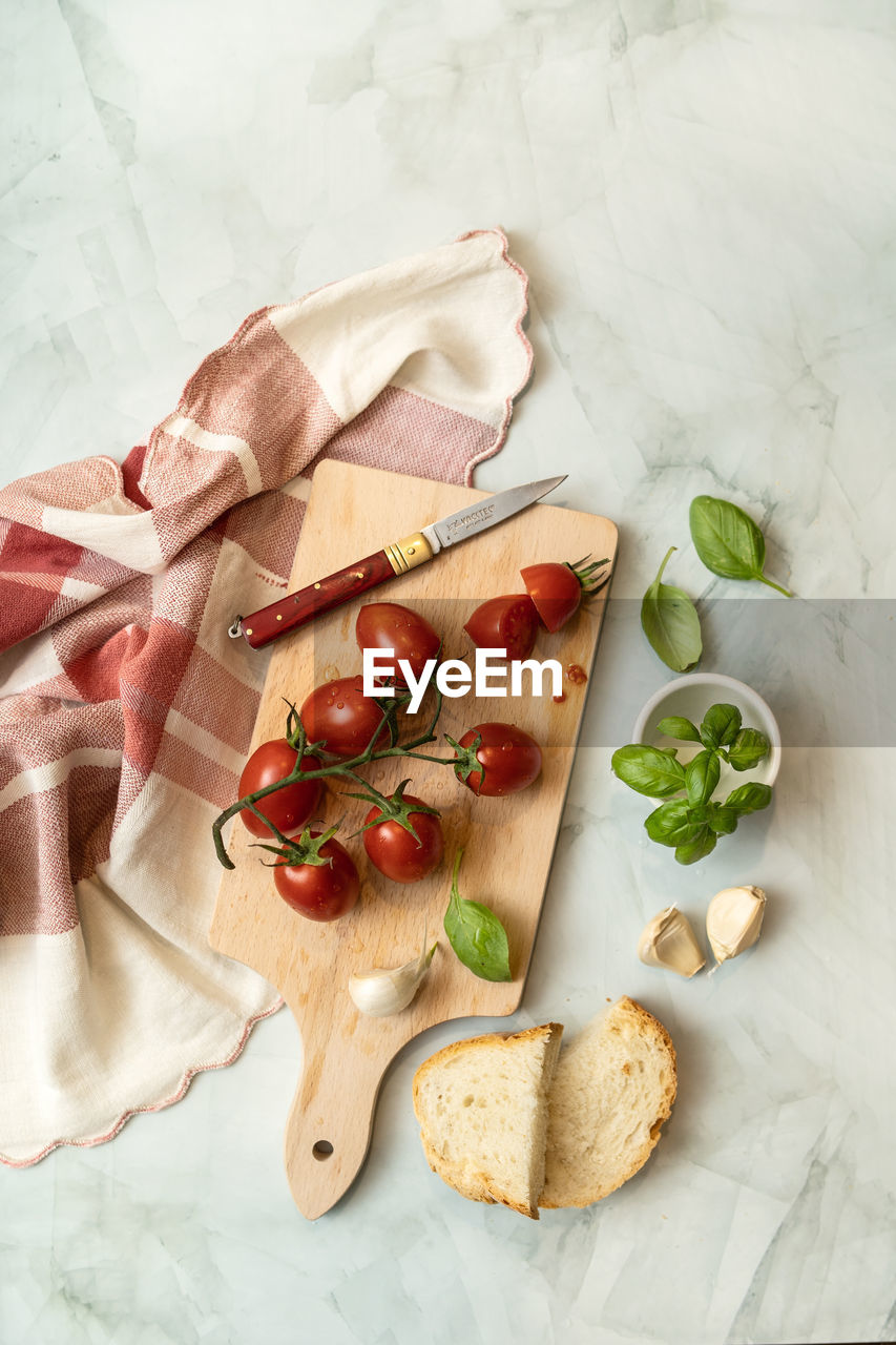 HIGH ANGLE VIEW OF BREAKFAST ON CUTTING BOARD ON TABLE