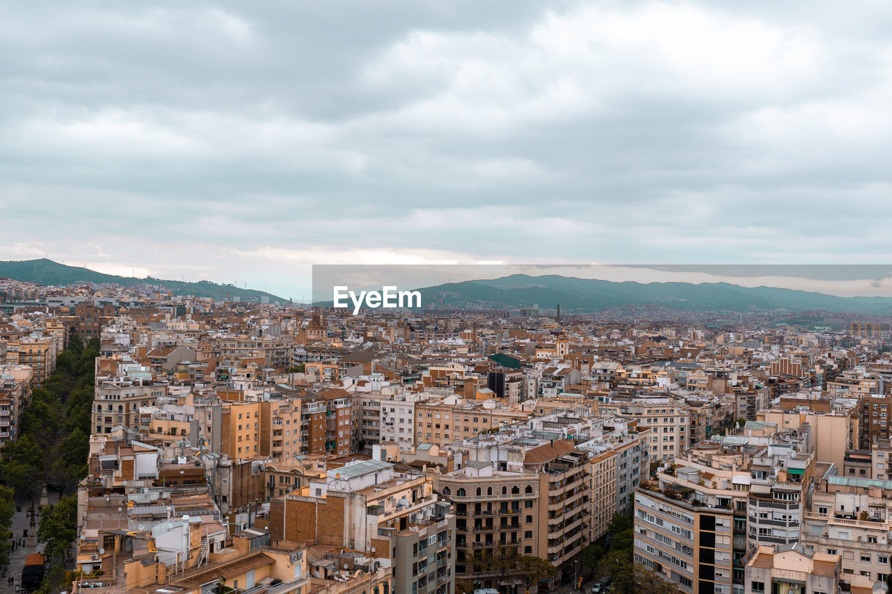 Top view of barcelona city with apartment buildings and mountains in the background