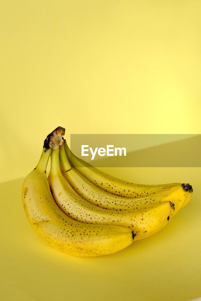 Close-up of yellow fruit banana against yellow background