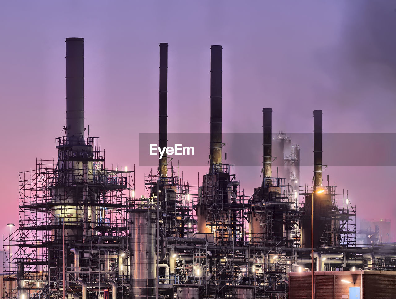 Low angle view of chemical plant against purple sky