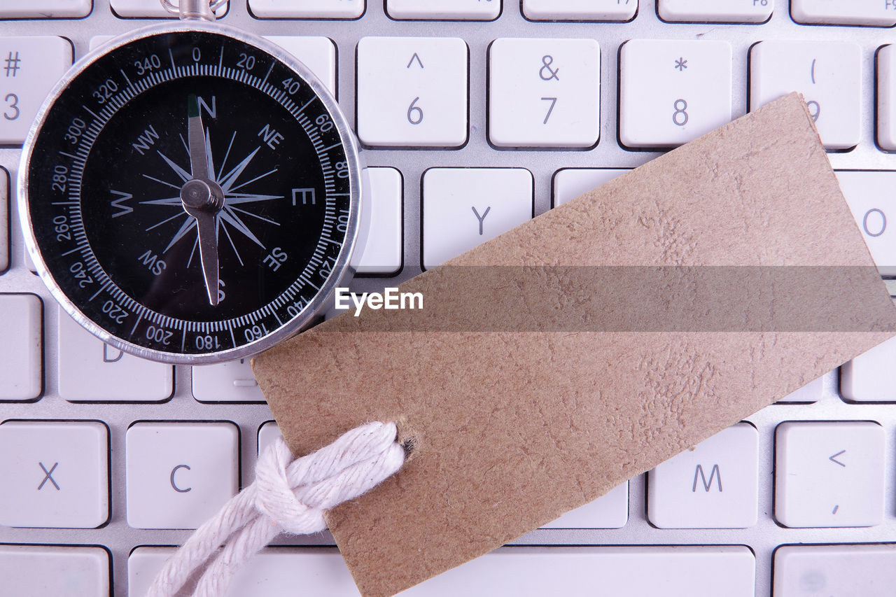 High angle view of navigational compass on keyboard