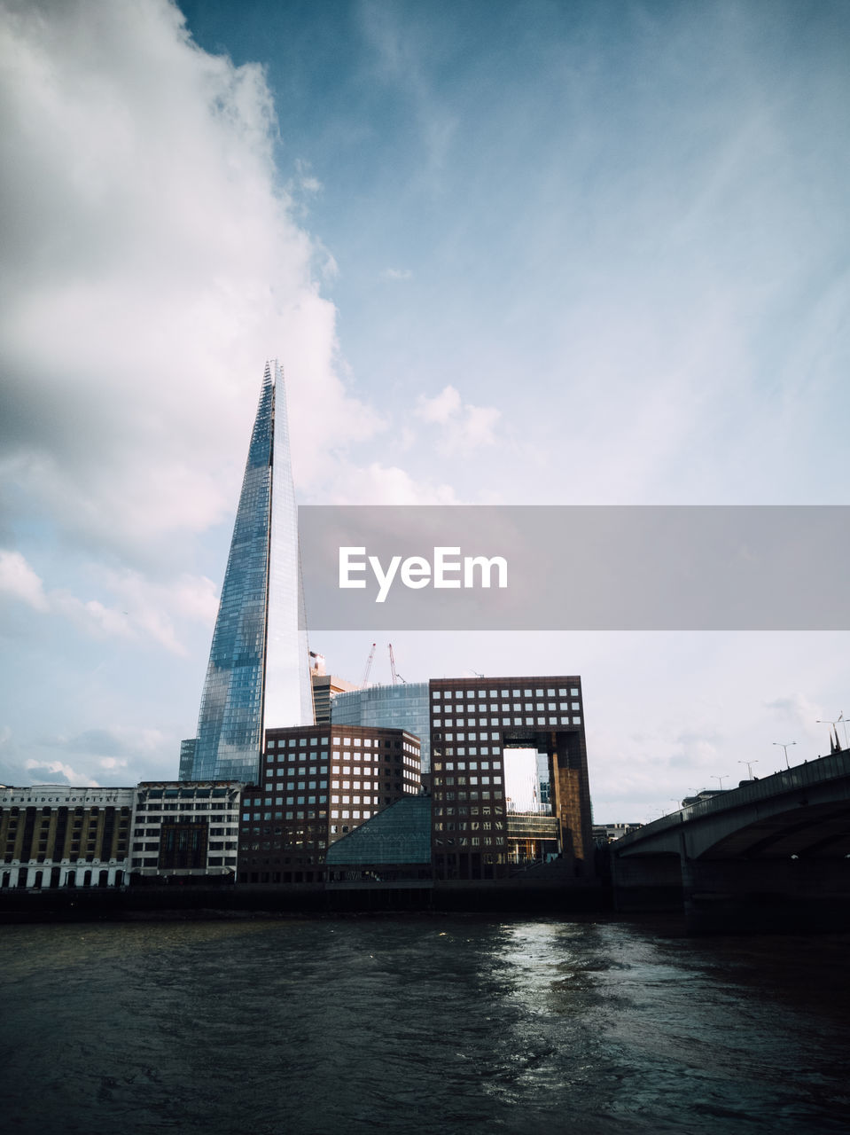 VIEW OF BUILDINGS BY RIVER AGAINST SKY