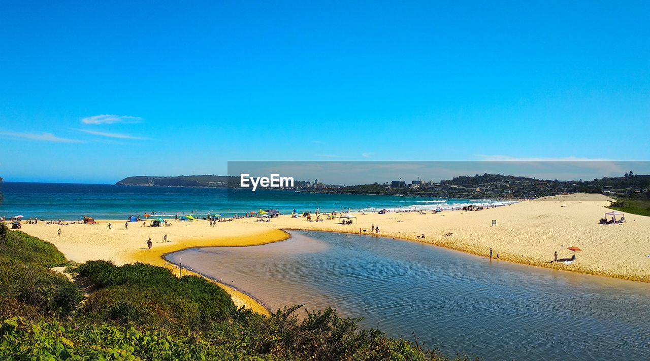 PANORAMIC SHOT OF BEACH AGAINST CLEAR BLUE SKY