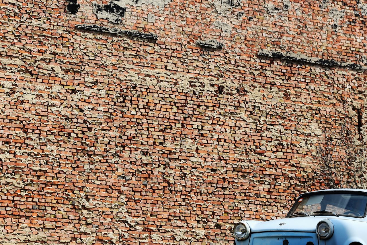 Car parked against brick wall