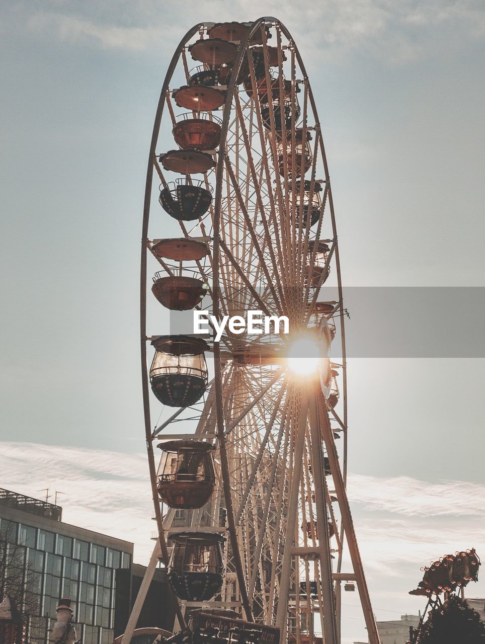 Low angle view of ferris wheel against sky during sunset