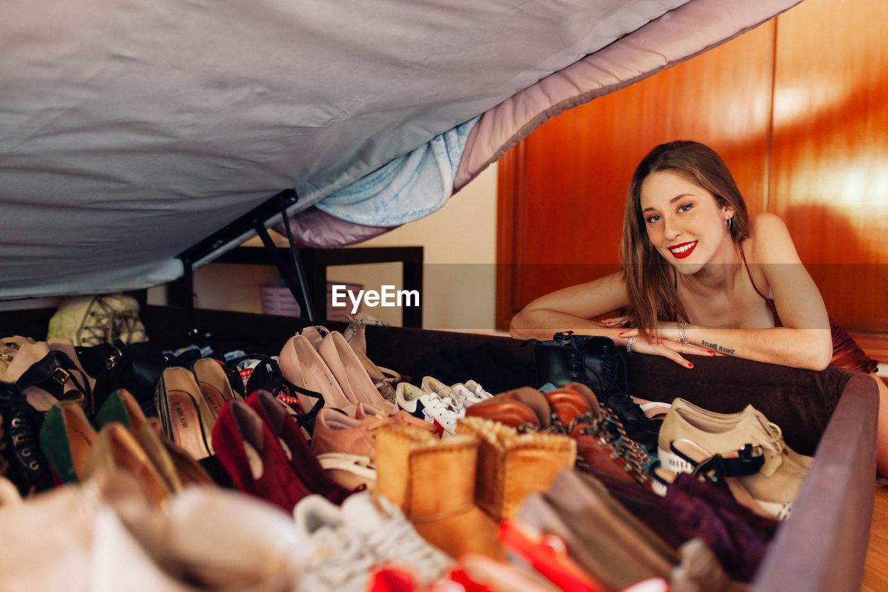 Teenager showing off her large collection of shoes, sneakers and heels.